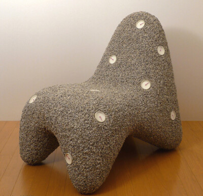 日本设计师小泉时钟石椅设计，这是一个不朽的椅子，它的有机形状花岗岩和环氧树脂时钟装饰，在黑暗中会发光。
