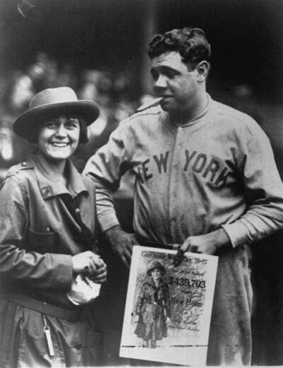 In this rare photo taken in 1923, the legendary Babe Ruth puts the bite on a Girl Scout cookie to help promote the Scout's Annual Cookie Sale