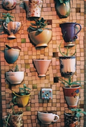 teacups embedded in mosaic and planted with succulents