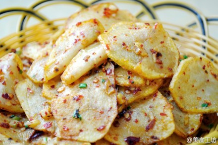 【酸辣土豆片】做法：备用烧一锅开水，放入土豆片煮熟，捞出煮好的土豆片，放入冷开水中浸泡片片刻，捞起沥干水分。放一大碗中。将糖，醋，酱油，辣椒油，花椒粉，鸡精，调入拌匀，炒锅烧热，倒入适量香油，并放入花椒，姜蒜碎爆香后，一起淋在拌匀的土豆片上，撒上葱花即可