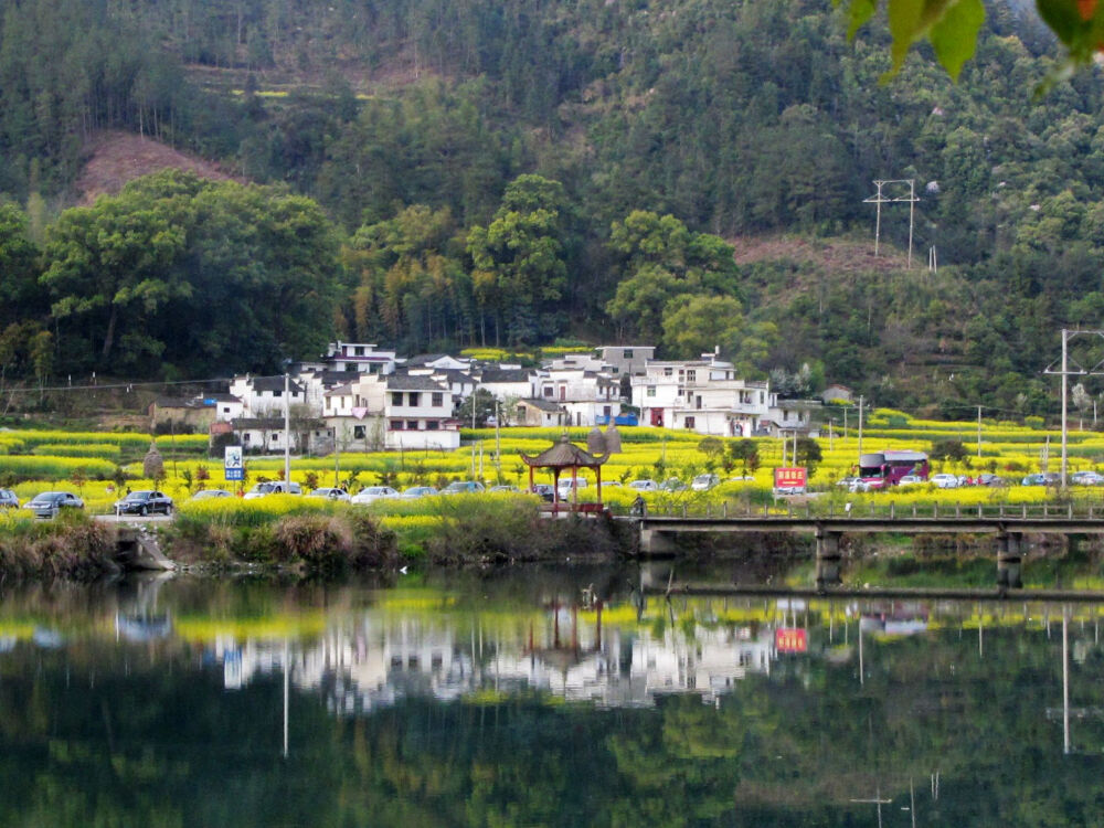 江西婺源。在旅人和车流穿行中，房屋和景致的一片宁静祥和。