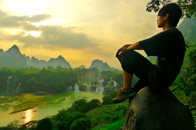 —— 宛若仙境的德天瀑布。德天瀑布位于中越边境广西省大新县硕龙镇，经过德天村处遇断崖跌落而成瀑布。河的一岸属于中国广西，而另一岸属于越南。黄昏时，夕阳刚好挂在瀑布上方，暮色中的瀑布如银帘高挂，似缟绢垂天，织上橘红偏暗的夕阳和晚霞，恍如仙境……