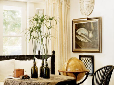 Black accessories, including rattan furnishings and iron curtain rods, give this breezy interior contrast.