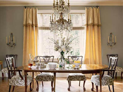 A double tiered crystal chandelier establishes a tone of elaborate formality in this Birmingham dining room. Designer Mary Evelyn McKee complements it with simple chair skirts and tailored curtains.