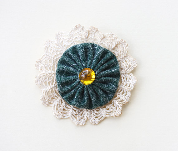 Green brooch pin I made the brooch with recycled vintage dark spring green Irish linen fabric and crochet doily on the back, orange acrylic rhinestone on front center. All parts are joined with hand sewing.And a brooch pin was sewn on the back. I dyed the crochet doily with black tea to give a vi