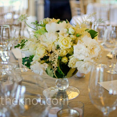 Low glass urns filled with white and green peonies, astilbe, lady’s mantle and garden roses topped the tables.