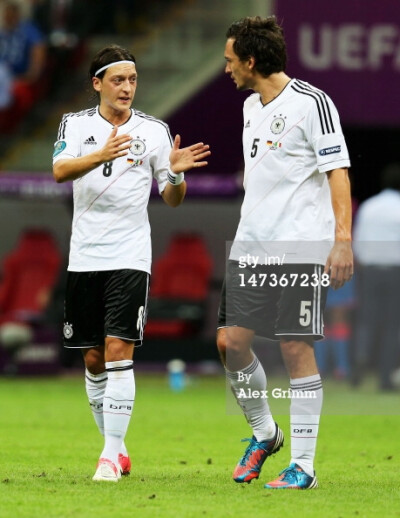 News Photo: Mesut Ozil of Germany speaks with team mate…