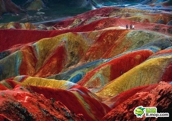  这是一个独特的、称为丹霞地貌的地质现象。在中国有好几个地方可以观察到这些现象。这个照片拍摄于甘肃省的张掖。土壤的颜色是数百万年的红色砂岩和其他岩石积累的结果。