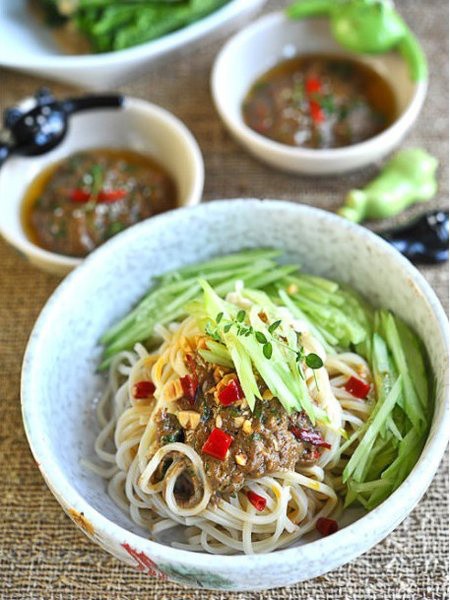 芝麻酱  黄瓜  冰块  花生酱  香菜  香油  面条  麻辣花生碎  白开水  生抽  辣椒油  糖  作法1.香菜洗净切碎，白芝麻锅中炒熟炒香。2.芝麻酱 花生酱 糖 生抽混合搅拌均匀。3.加入适量清水，边加入边用筷子顺着一个方向澥开麻酱，稀稠根据自己喜好自由掌握。4.加入盐、熟的白芝麻和泡椒混合均匀。再淋上香油和辣椒油混合。5.再加入香菜碎混合，万能的芝麻酱调料就做好了。6.面条入锅煮熟。7.白开水倒入碗中，加入适量的冰块