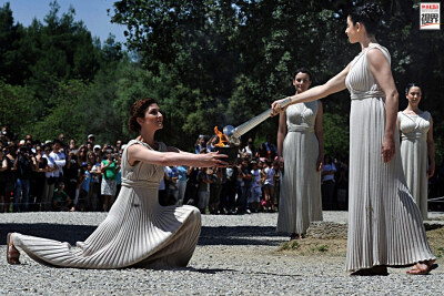 圣火采集 2012年5月9日，女祭司伊诺?梅妮佳奇手捧圣火在古奥林匹亚遗址进行最后的奥运圣火传递彩排。