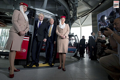 新的交通工具投入到伦敦奥运中 2012年6月28日，伦敦市长鲍里斯-约翰逊(左二)和阿联酋航空公司的总裁,蒂姆-克拉克(左三)与阿联酋航空公司空姐合影,该公司在东伦敦新建的缆车系统将搭载观众和运动员,周四对公众开放。…