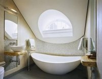 阁楼里的卫生间，特别喜欢空间内丰富的曲线，窗是半圆形的，窗下沿的弧形，以及月亮形的浴缸，韵味十足。