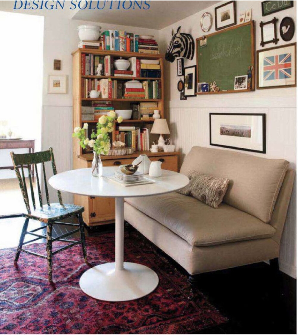 可爱的起居室，书架、墙上的小黑板、招贴画、简约的沙发和桌子、旧椅子。