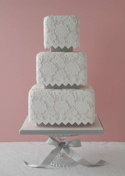 Here is a traditional white lace design on pale pink cake. This wedding cake is gorgeous...no matter how you slice it! by colette