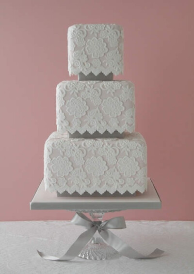 Here is a traditional white lace design on pale pink cake. This wedding cake is gorgeous...no matter how you slice it! by colette