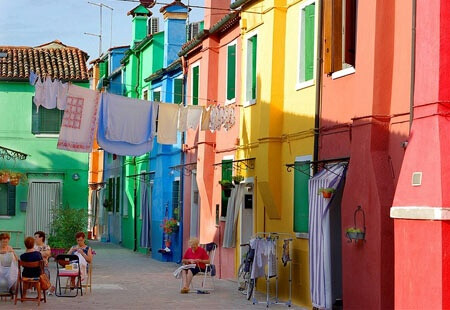  【Burano 布拉諾島】是義大利威尼斯潟湖上的島嶼，以手工蕾絲和彩色房子聞名於世。據說1481年達芬奇從希臘小城鎮Lefkara購回米蘭大教堂使用的壇布後，引進了花邊蕾絲，此技術於該島上生產製作，日後逐漸成為當地特產。彩色的房子其實最初是為了辨識家門的標示，居民確定顏色後必須向政府申請通過，才能彩繪，不同樣顏色的小房子並列，形成像童話故事裡才會有的彩色世界，相當可愛。