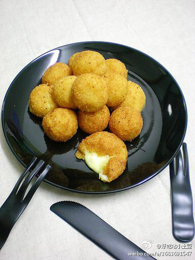 【芝心薯球】1.土豆洗净加水煮熟,去皮后用勺压成泥,加奶粉.糯米粉.盐和胡椒粉,揉成不粘手的面团;2.将土豆面团分成剂子,每个剂子包入芝士片,搓圆后均匀滚上面包糠;3.油锅烧至5成热,放入土豆球,小火炸至表面金黄.外壳稍硬即可~捞出后用厨房纸吸去余油,趁热吃口感最好