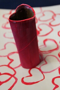 Heart stamping using paint and a toilet paper roll.