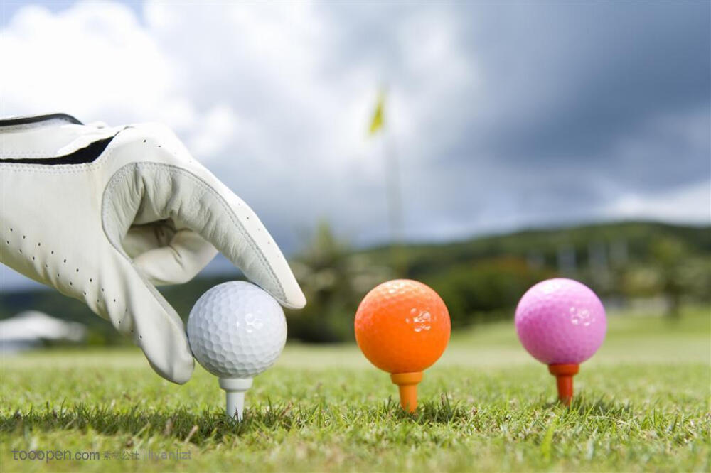 放高尔夫球的手和三种色彩的高尔夫