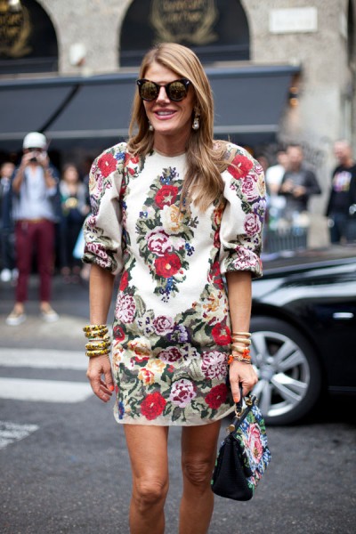 Anna Dello Russo 身着 Dolce & Gabbana 印花耸肩连衣裙，提包的印花也与裙装配套。