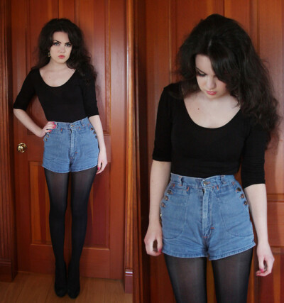 大圆领口七分袖黑上衣搭配蓝色高腰牛仔短裤。