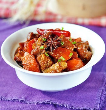 【红焖羊腩】1羊腩切块焯水洗净备用，胡萝卜洗净切滚刀块。姜切片。 2、锅里放油，冷油下八角，草果，一起小火烧，炸出香味。放入姜片，羊肉，一起中火煸炒到羊肉微微干松出油。边缘微黄即可。（过程需要三到五分钟，边煎边炒，炒几下停一会。） 3、放入蒜子，干辣椒一起炒均匀出香味。（一到两分钟。）放料酒，生抽，老抽，五香粉，一起翻炒均匀。兑水，放冰糖，大火煮开小火煮30分钟。 4、放入胡萝卜，调入盐，文火焖40——60分钟。 5、大火收汁，调入鸡精或者味精提味即可。