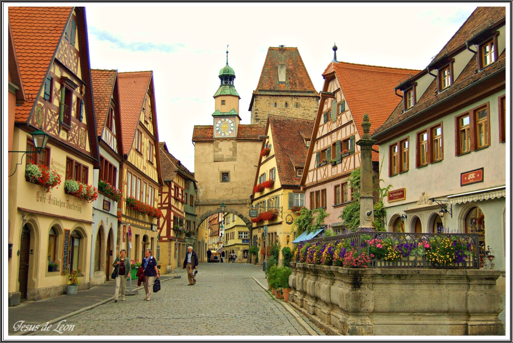 【羅騰堡Rothenburg ob der Tauber】位在德國陶伯河上的中世紀古城，歷史上幸運多次躲過戰爭得以保存完整的童話王國，市政廳為中心點道路成放射狀展開，尖尖紅瓦屋頂、德國傳統木椼建築、石磚路為主要特色，每年遊客量達150萬人次，有中世紀寶石之稱。1618年當時將軍與敵軍剎賭喝下3.25公生的葡萄酒，使此城免於戰爭，市議會宴會館(Ratstrinkstube)有人偶時鐘表演紀念那位將軍。據傳***東征後，耶穌聖血被帶到此地，存放於聖雅各教堂(St.Jakobs Kirche)內十字架的水晶球裡。其中普隆來恩廣場(Plonlein)為最具代表的拍攝景點。