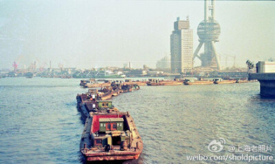 1992年，黄浦江上经常能看到这种首尾相连的船队，背景是建设中的东方明珠广播电视塔。呀，是我出生的那一年。