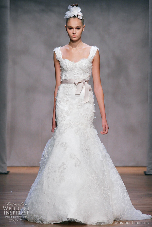 Monique Lhuillier wedding dress, Fall 2011: Aspen - ivory embellished chantilly lace elongated corset bodice gown with exaggerated trumpet skirt, embellished straps and covered all over with organza embroidered flowers, shown with cameo hyacinth ribbon sash