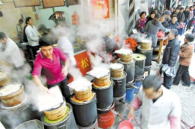 虞师里矮人松糕店 蒸出浓浓年味来 在市区虞师里矮人松糕店前，市民排起了“长龙”等待出炉的松糕。据店主介绍，春节临近，过来买松糕的人特别多，他们已将平时的3个炉灶增加到了10个，但出炉松糕还是供不应求。