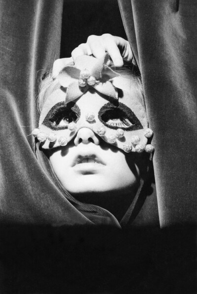 From the Vogue archive: A young Twiggy wearing a mask and peeking through the curtains of the Paris shop Torrente, 1967 #vogue365