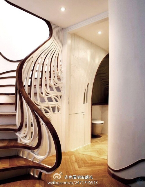 这个极具雕塑感的楼梯是由伦敦事务所atmos studio的设计师alex haw为一栋私人住宅设计的，这个独特的楼梯在住宅空间中扭动，并将自己流动的形态与地脚线图案有机的融为一体。为了与已有的空间布置相协调，设计师希望在视觉上将这个楼梯间和其它生活空间联系起来，楼梯扶手向下延伸到浴室中，并顺着墙面伸展开来，缠绕了周边的家具，将本身的形态完全融入到空间中。