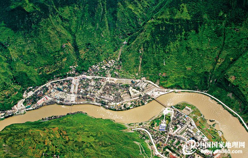 流淌在四川泸定的大渡河水流湍急，河岸两侧山谷陡峭。由于可开垦居住的土地非常有限，泸定县城只能建在山麓的冲积扇上。从空中可以清楚地看到，两岸的冲积扇几乎完全被密集的房屋建筑所覆盖，一座公路桥连接着大渡河两侧的交通。河面上还可看到一条铁索桥，那就是大名鼎鼎的泸定桥。