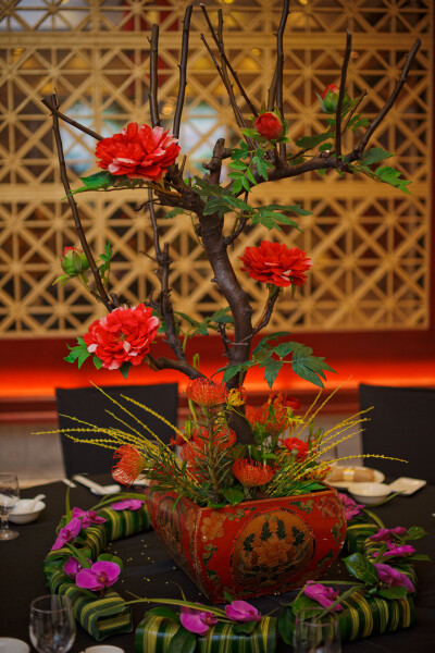 康宁婚礼策划 给婚礼加上禅的韵味——现场桌面布置也相当古色古香，红色桌花盆栽是中式婚礼中的重要喜庆元素。