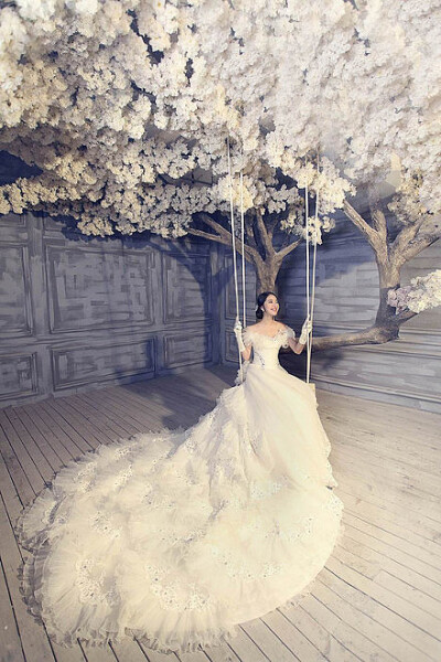 由树的高大体现新娘的娇小美丽，由白灰为背景颜色承托婚姻的纯洁无暇