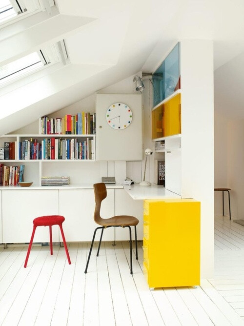 12 White Rooms with Pops of Color: Under the eaves proves to be a great space for a study. Books provide color, along with the backs of the bookshelves above the writing space, the file cabinet, and stool.