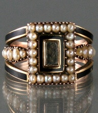 Rare Georgian 9 carat rose gold mourning ring set with a central crystal glass compartment with hair under surrounded by seed pearls and black enamel , there is black enamel and pearls to the shoulder…