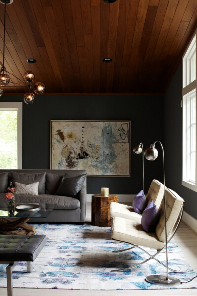 cozy cool living space. love those chairs + the lights.