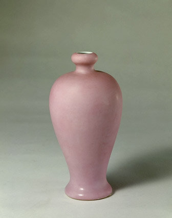 清雍正淡粉釉瓶（故宫藏品）——高19.5cm，口径2.2cm，足径6.7cm。 瓶口内敛，口形如蒜头，短颈，丰肩，肩以下渐敛，圈足微外撇。通体施淡粉色釉，属低温金红釉。瓶里及底均施白釉。底青花双圈内楷书“大清雍正年制”六字款。 此瓶胎质洁白细润，造型秀美，釉色均匀纯正，淡粉色如三月桃花，淡雅宜人。金红釉瓷器为雍正时创烧，在官窑传世品中亦很罕见。此瓶是典型的雍正官窑制品，为传世之珍。