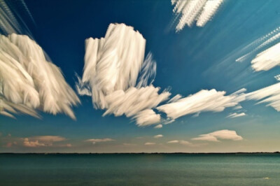 加拿大摄影师Matt Molloy通过将上百张照片堆叠的方法，捕捉到瞬息万变的云朵移动的痕迹，创作出了这些奇幻的风景作品，仿佛将云彩用笔刷涂抹于天际。