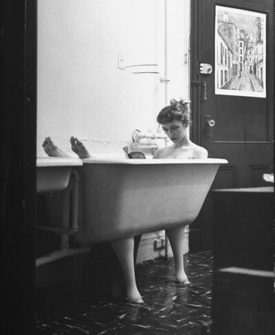 Jo Ann Kemmerling reading a book while taking bath, New York.