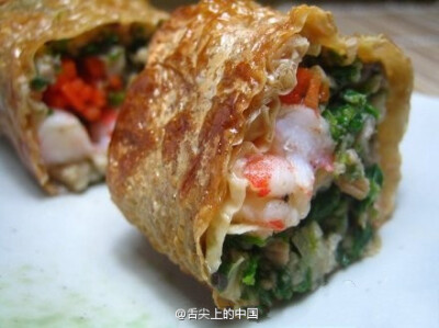 【豆腐鲜虾卷】1.虾去壳，虾线留着小尾巴，加盐，鸡精，料酒 抓匀腌制十分钟；2.豆腐用刀压碎，加盐，鸡精，蛋清拌匀；3.红肠用刨子刨出薄片，在上面加上适量豆腐泥，一只虾仁；4.从一边卷起来，用香菜梗扎好；5.上…