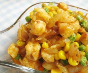 【咖喱什锦虾仁】热油锅，放入洋葱碎，小火翻炒至出现洋葱香味；咖喱块融化后，翻炒洋葱碎，使其入味儿；倒入虾仁段，转中火，翻炒，炒至虾仁变红并炒出红色虾油；倒入玉米粒和豌豆，翻炒；加入盐和黑胡椒碎，翻炒均匀即可。