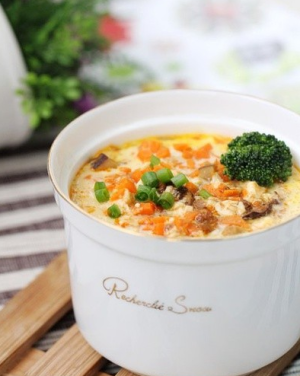 【肉酱豆腐盅】1.鸡蛋打散，香菇与金针菇切碎，青花菜焯水备用；2.将盒装豆腐倒入大碗中，加入少许白胡椒粉、胡萝卜末、香菇末；3.加好配料之后，添加一茶勺土豆淀粉并加入蛋液与肉酱拌匀，然后封保鲜膜大火蒸7分钟，撒香葱与青花菜装饰即可.