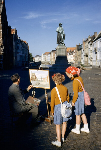 Girls watch artist painting picture of statue of Flemish artist in Bruges, Belgium, May 1955, photograph by Luis Marden