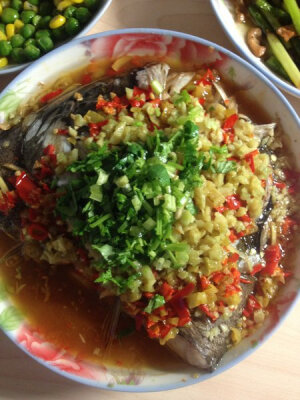 剁椒鱼头 材料 鱼头  一个 大蒜  一个 香菜  少许 盐  各一匙 味精  各一匙 青红辣椒各两个  2 姜  一个 泡椒  一袋 美味鲜  各一匙 <br />料酒  各一匙 <br />作法 <br />1.将鱼头劈开整理干净，将盐和料酒涂抹淹好待用 <br />2.待鱼天淹制时把姜蒜各种辣椒剁碎待用！将蒸锅上水烧沸等锅开后上鱼头先铺一层我们剁好的青辣、在铺姜、在铺大蒜、在铺泡辣最近铺教辣椒大火蒸30分钟 <br />3.待鱼头起锅倒掉盘内多余水份、制炒锅中倒入食用油烧至八成热加少许美味鲜和味精淋至鱼头之上