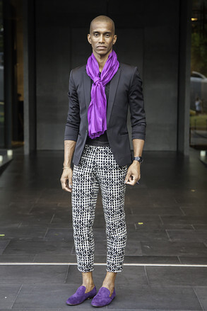 泰国曼谷, Eric Raisina是一名时装设计师，其着装如下：Eric Raisina Haute Texture的围巾，泰国品牌Theatre的裤子，Donna Karan New York的外套