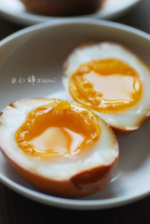 【溏心卤蛋】做法：1、生的鸡蛋，先用针在尾部蛋壳上扎一个小孔。2、烧一锅开水，水沸腾后，用勺子装着鸡蛋，轻轻放入锅中。3、调中小火，煮7分钟。4、时间到后，马上捞出鸡蛋，放入冰水中降温15分钟。5、降温后的鸡蛋，剥去壳，放入温热或冷的卤水中浸泡一夜，中途要翻面。