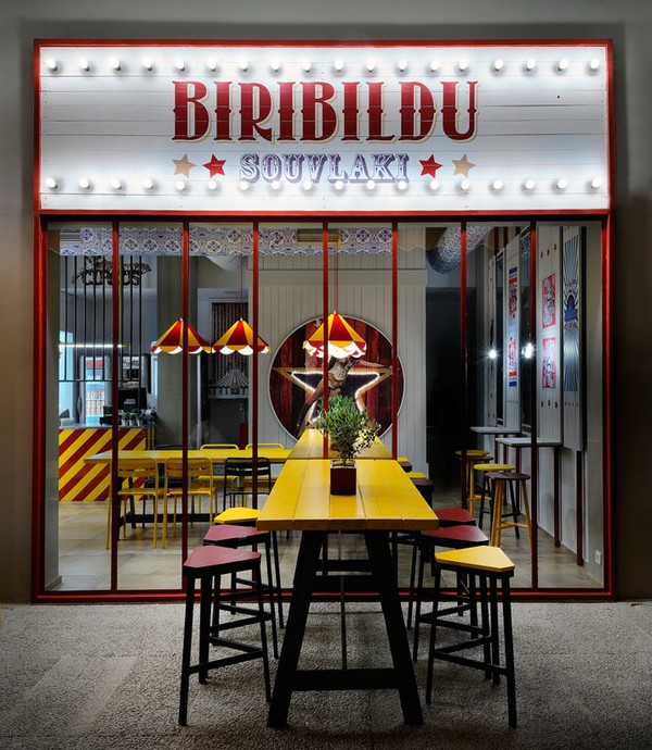 欢笑和美食永远最能抚慰人心。在希腊雅典，一家名为“Biribildu”的餐厅愉快地将两者结合到一起。室内设计师 Minas Kosmidis 把旋转木马、铁栅栏、表演女郎都拉进来，用餐环境被布置得色彩缤纷、充满趣味。设计师想要表达的是：享用美食有时候就像看这些荒谬的把戏，享受每一刻，不要让它溜走。