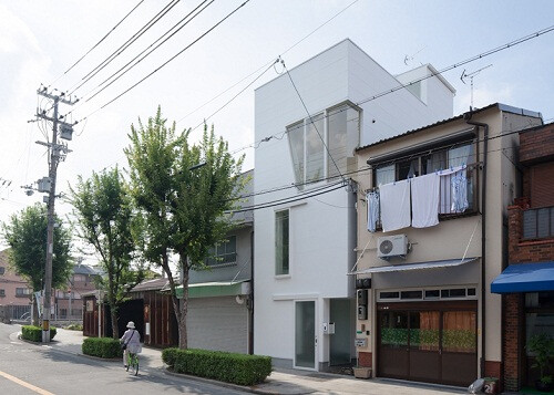 “House in Tamatsu”住宅，位于日本大阪市街區(qū)，由井戸健治建筑研究所為一戶有兩個小孩的家庭設(shè)計。 項(xiàng)目占地僅43.21平方形，之前是一幢雙層木制建筑，由于與周圍建筑密切相鄰，使其不能達(dá)到理想的采光狀態(tài)。新項(xiàng)目將其改造為三層建筑，第二層和第三層的房間布局采用14度的旋轉(zhuǎn)設(shè)計，使室內(nèi)墻壁與外墻形成一個空白夾角，直通向天臺，將來自頂部的自然光線引入室內(nèi)。